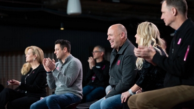 Grupo de miembros del equipo directivo de T-Mobile aplaudiendo.